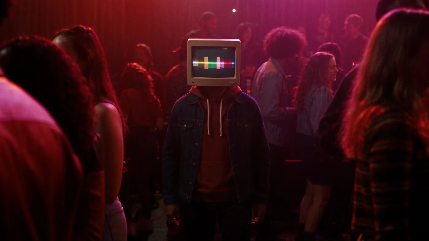 Alone in a crowded club, colour bars glowing on his face